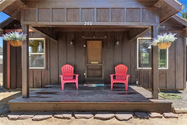 property entrance with a deck and board and batten siding