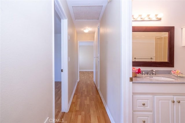 hallway featuring light hardwood / wood-style flooring and sink