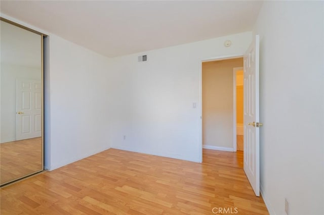 unfurnished bedroom with light hardwood / wood-style floors and a closet