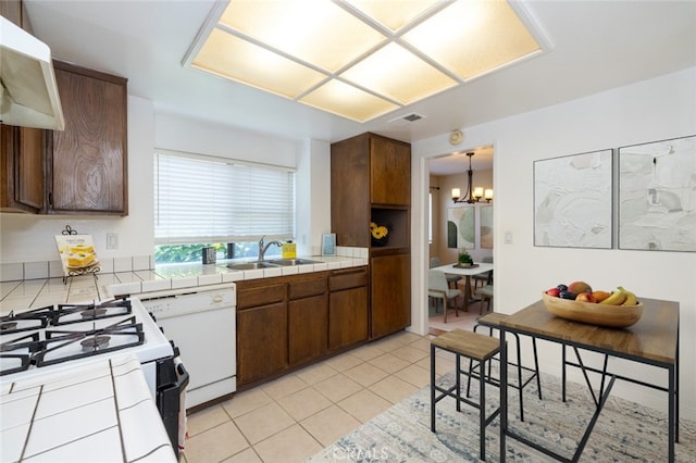 kitchen with white appliances, exhaust hood, sink, tile counters, and light tile patterned flooring