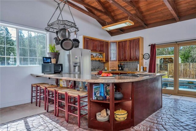 kitchen featuring vaulted ceiling with beams, a healthy amount of sunlight, wooden ceiling, and kitchen peninsula