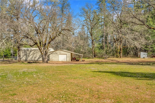 view of yard featuring an outdoor structure and a garage