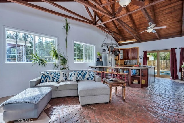 living room with beam ceiling, high vaulted ceiling, ceiling fan, and a healthy amount of sunlight