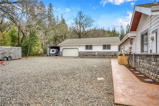 view of yard featuring a garage and a carport