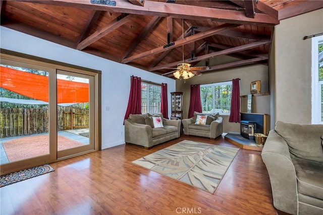 unfurnished living room featuring a wood stove, ceiling fan, vaulted ceiling with beams, wood ceiling, and hardwood / wood-style flooring