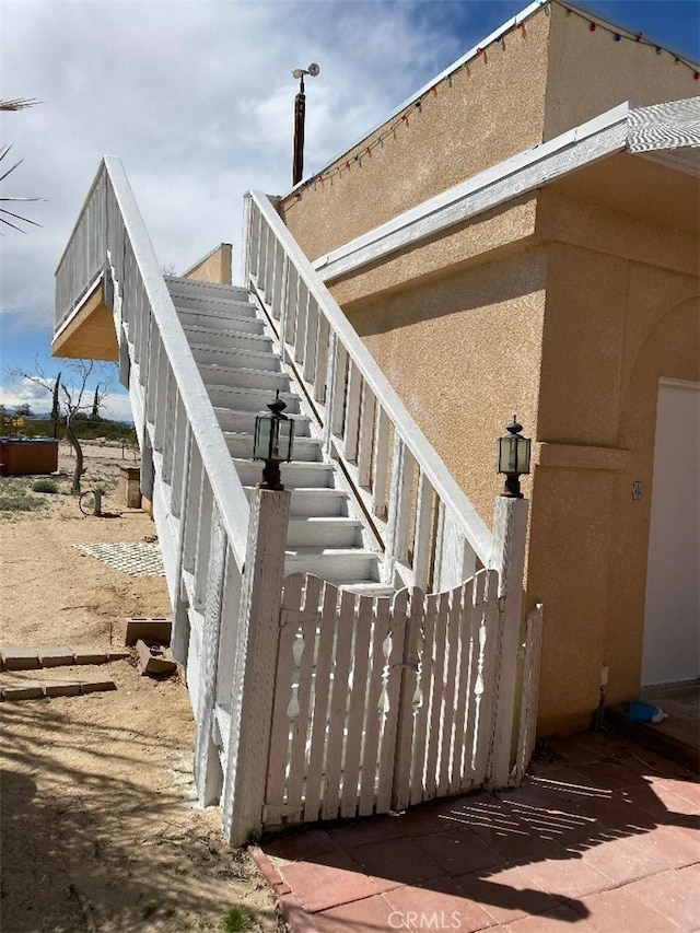 view of home's exterior with stairs and stucco siding