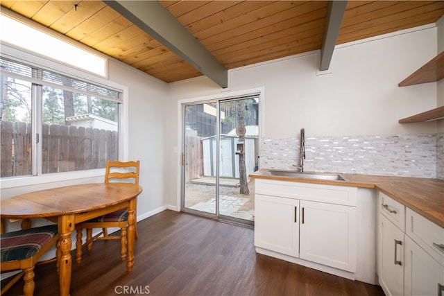 dining area with wooden ceiling, beamed ceiling, dark hardwood / wood-style floors, and sink