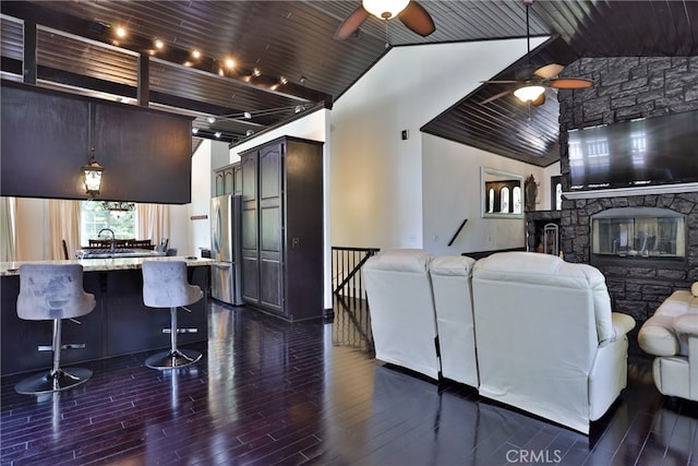 kitchen with dark wood-type flooring, stainless steel fridge, hanging light fixtures, and wooden ceiling