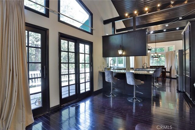 24048 Altdorf Dr, Crestline, CA 92325 - kitchen with freestanding refrigerator, a peninsula, a towering ceiling, a breakfast bar area, and light stone countertops