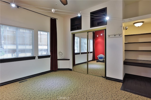 interior space with a closet, ceiling fan, and carpet flooring