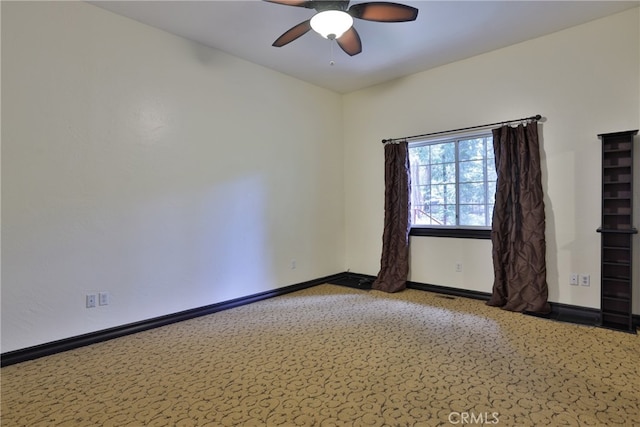 carpeted empty room featuring ceiling fan