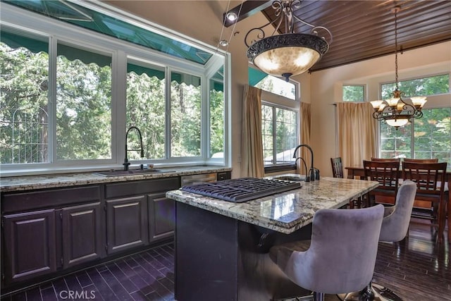 24048 Altdorf Dr, Crestline, CA 92325 - kitchen with light stone counters, a chandelier, stainless steel appliances, decorative light fixtures, and a center island with sink