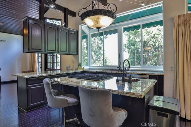 24048 Altdorf Dr, Crestline, CA 92325 - kitchen featuring light stone countertops, stainless steel gas cooktop, dark wood-type flooring, a kitchen island with sink, and vaulted ceiling