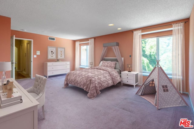 bedroom with a textured ceiling and carpet