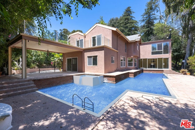 view of swimming pool featuring a patio and a jacuzzi