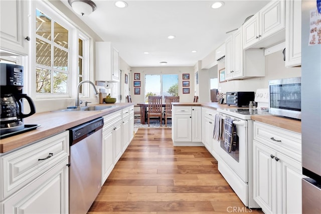 kitchen featuring light hardwood / wood-style flooring, white cabinets, and appliances with stainless steel finishes