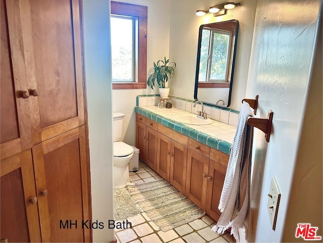 bathroom featuring vanity, toilet, and tile patterned flooring