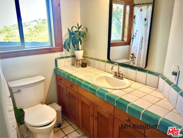 bathroom featuring toilet, vanity, and tile patterned flooring