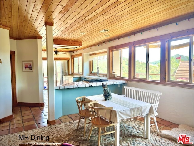 dining room with a healthy amount of sunlight, wooden ceiling, and tile patterned floors