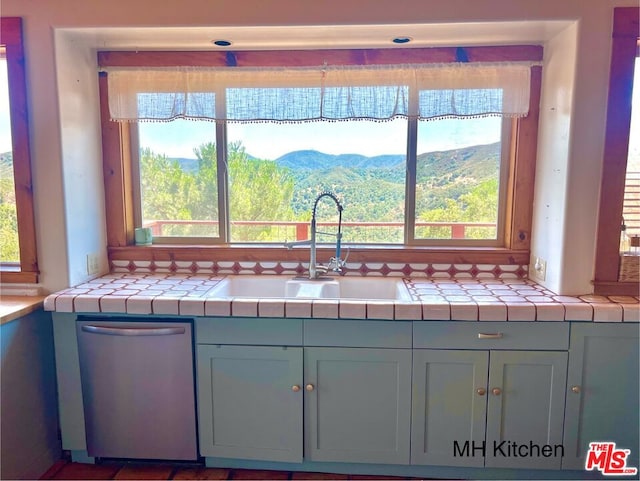 kitchen featuring sink, tile countertops, a mountain view, and dishwasher