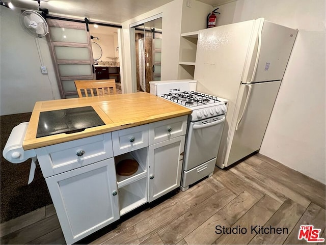 kitchen with wooden counters, a barn door, wood-type flooring, range with gas stovetop, and white refrigerator