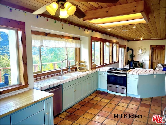 kitchen featuring tile countertops, a healthy amount of sunlight, stainless steel appliances, and sink