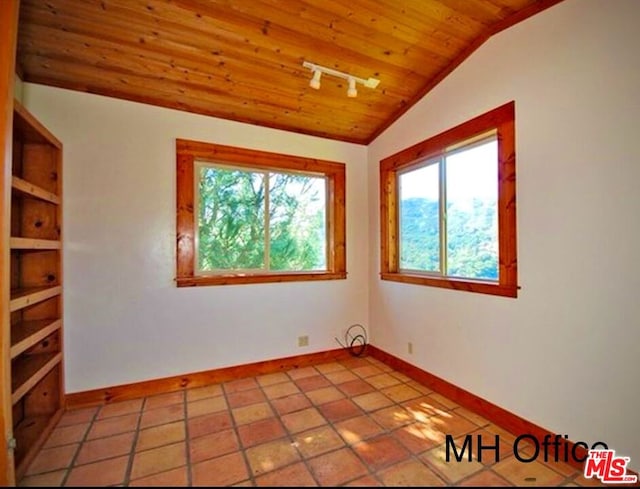 empty room with wood ceiling, light tile patterned floors, and vaulted ceiling