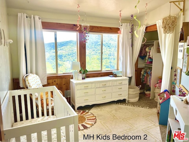 carpeted bedroom featuring a crib and wooden walls