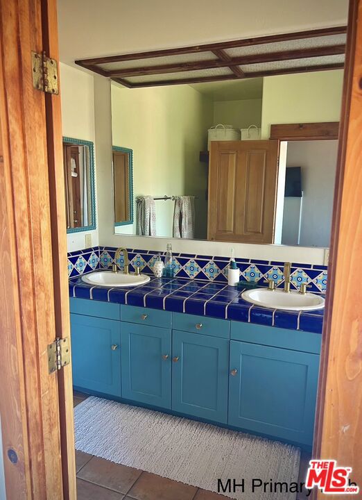 bathroom with vanity, tasteful backsplash, and tile patterned floors