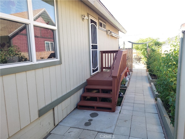 view of property exterior featuring a wooden deck and a patio area