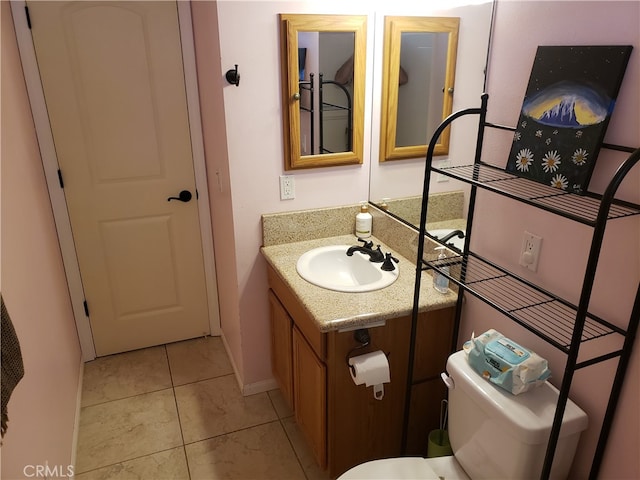 bathroom featuring tile patterned flooring, vanity, and toilet