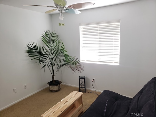 living area with carpet and ceiling fan