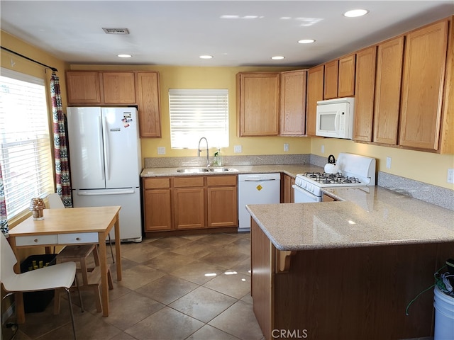 kitchen featuring dark tile patterned floors, kitchen peninsula, sink, and white appliances