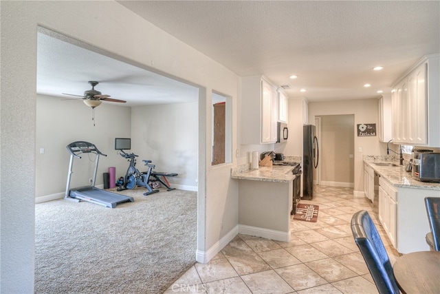 kitchen featuring light colored carpet, stainless steel appliances, sink, and white cabinetry