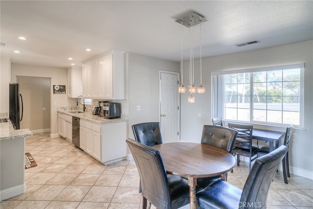 tiled dining space with a textured ceiling and sink