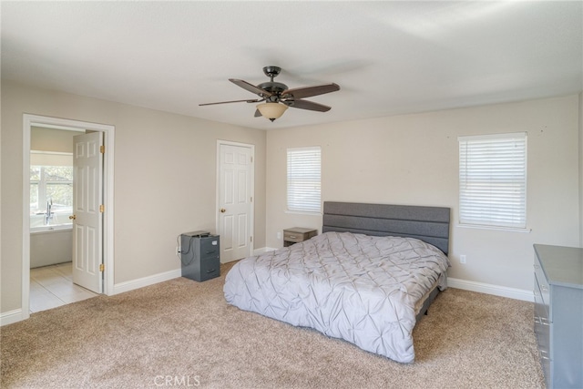 carpeted bedroom with ceiling fan and ensuite bath