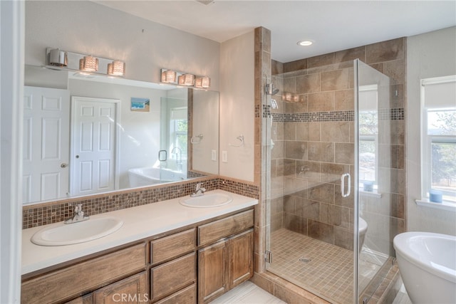 bathroom featuring decorative backsplash, shower with separate bathtub, and vanity