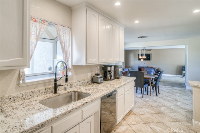 kitchen with hanging light fixtures, white cabinetry, dishwasher, light stone countertops, and sink