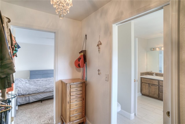 hallway with sink and a chandelier