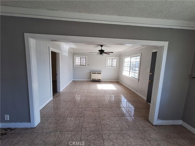 unfurnished living room featuring crown molding, heating unit, ceiling fan, and a textured ceiling