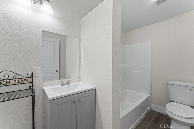 full bathroom featuring shower / tub combination, vanity, wood-type flooring, and toilet