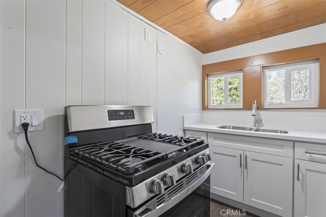 kitchen with white cabinetry, wood ceiling, sink, and stainless steel range with gas stovetop