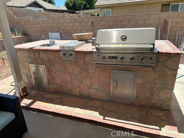 view of patio / terrace featuring sink, a grill, and exterior kitchen