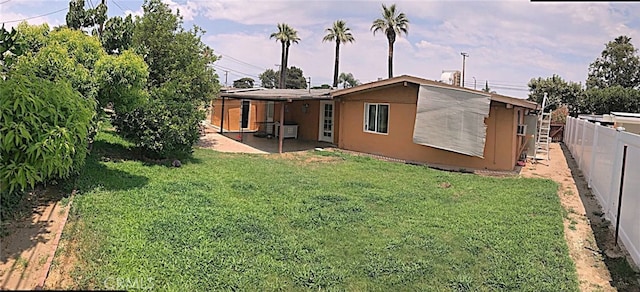 rear view of house featuring a yard and a patio