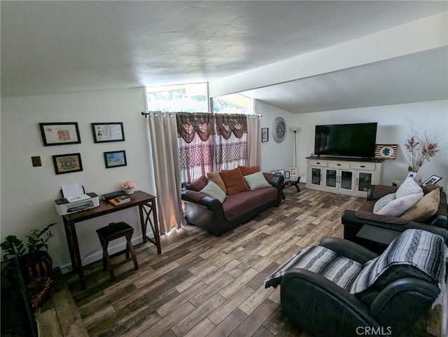 living room featuring vaulted ceiling with beams and dark hardwood / wood-style floors