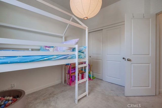 bedroom featuring light carpet, vaulted ceiling, and a closet