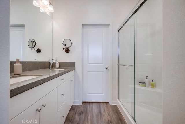 bathroom featuring hardwood / wood-style floors, an enclosed shower, and vanity