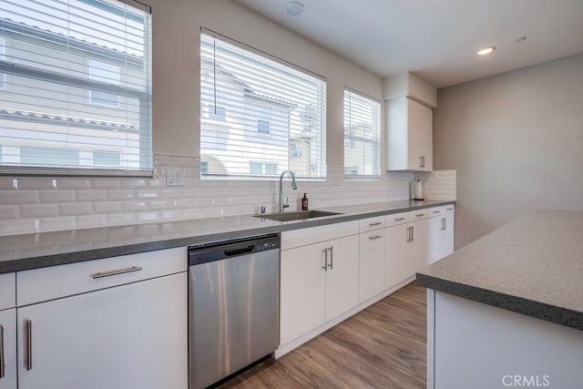 kitchen featuring light wood-type flooring, dishwasher, sink, and white cabinets