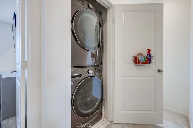 washroom featuring light carpet and stacked washing maching and dryer