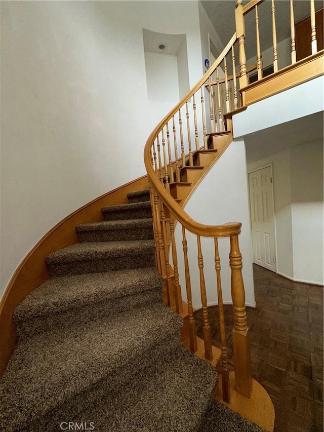 staircase featuring parquet flooring